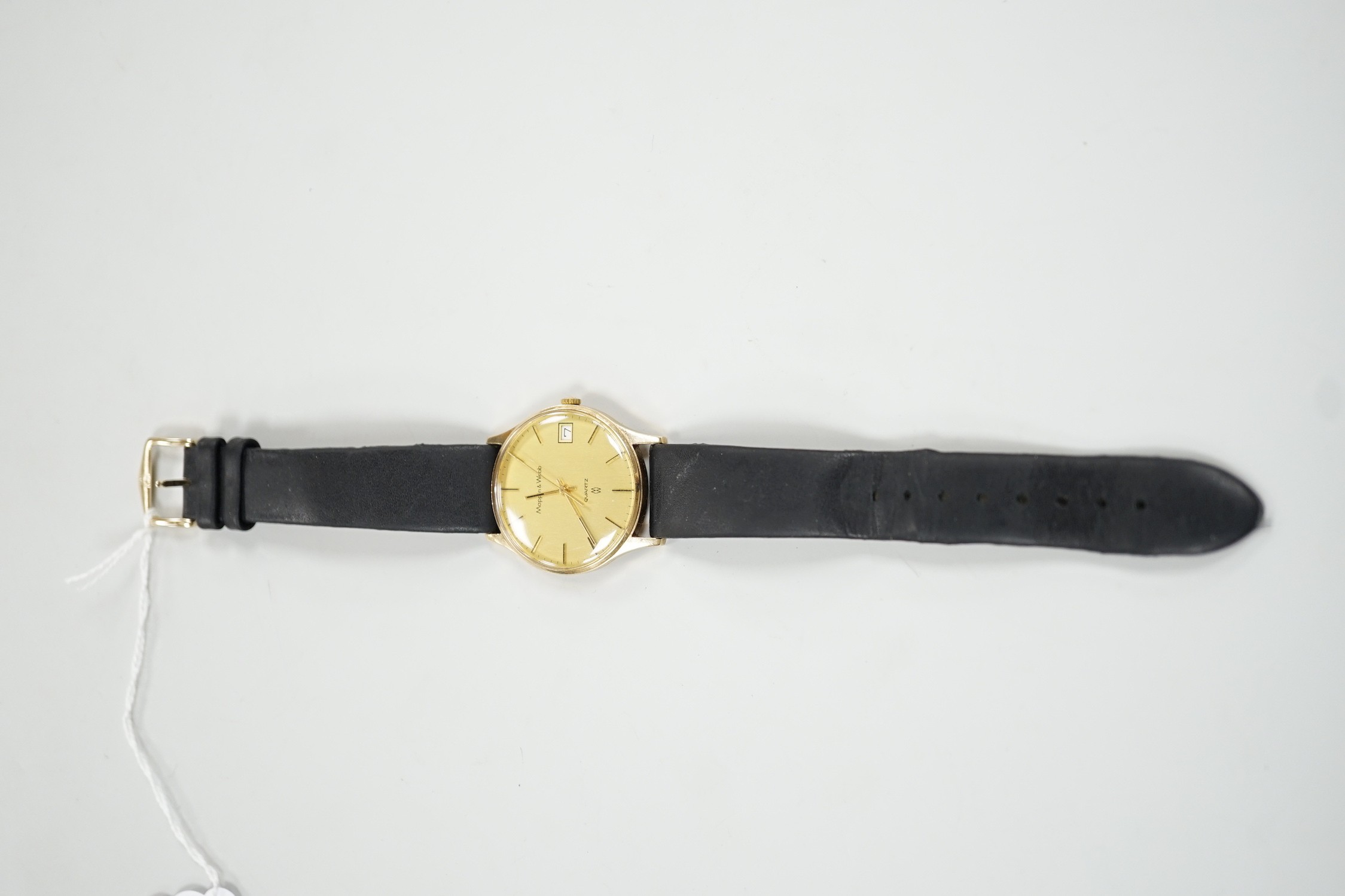 A gentleman's yellow metal quartz dress wrist watch, retailed by Mappin & Webb, with date aperture, case diameter 34mm, on a leather strap.